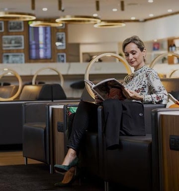 Femme assise dans un salon de l’aéroport Lyon Saint-Exupéry.